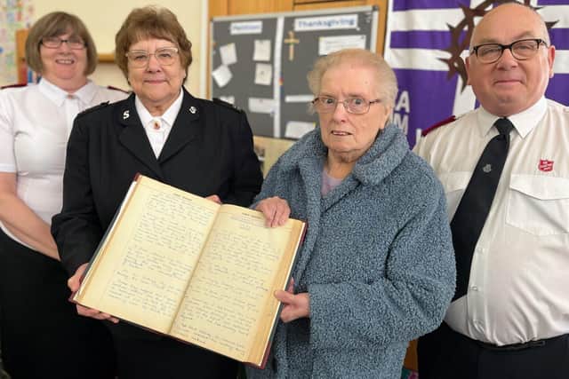 Church members celebrate the anniversary with a history book dating back to 1881. Pictured are Margaret Fordham, who is number one on the church roll, along with church historian Dorothy Harris and Majors Paul and Carolyn Wilson, commanding officers