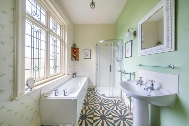 An elegant bathroom with tiled floor and leaded windows.