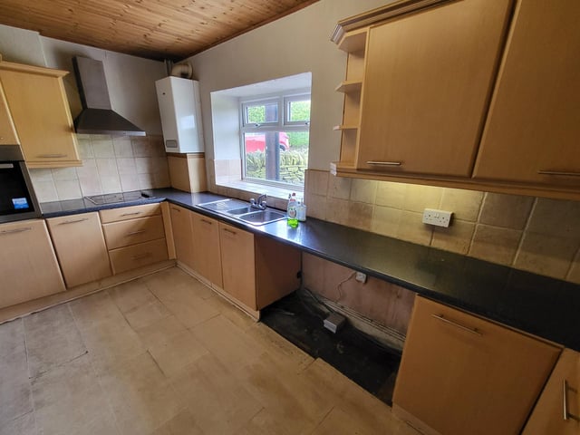 Fitted units in the kitchen include an integrated cooker.