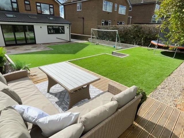 The tiered rear garden with decked seating area and artificial lawns.