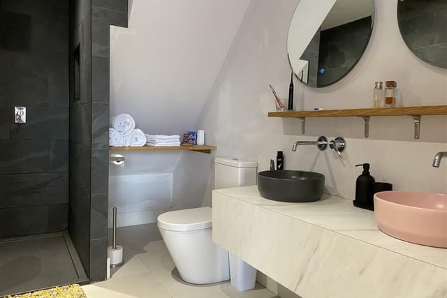 This suite is fitted with contemporary tiles and features a free standing bath, a separate walk-in shower, a low flush wc, a wall mounted wash basin and a heated towel radiator.