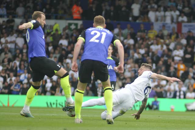 Liam Cooper stretches to make a tackle on Harry Kane.