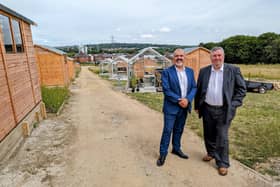 Coun Shabir Pandor, Leader of Kirklees Council, and Coun Graham Turner, cabinet member for growth and regeneration, on a pathway in front of several of the allotments