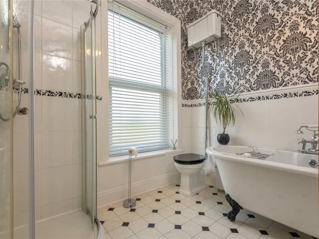 A deep, free-standing bath and a walk-in shower feature within this house bathroom.