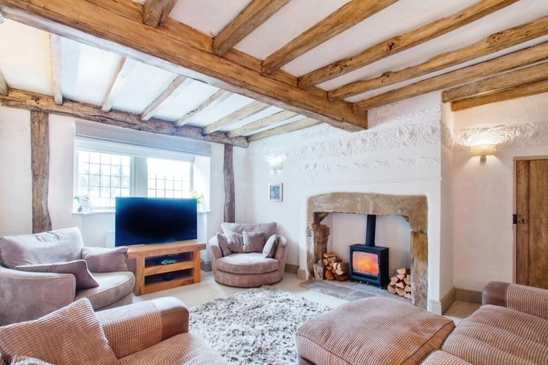 A beamed lounge with feature fireplace and log burner has a rustic flavour.