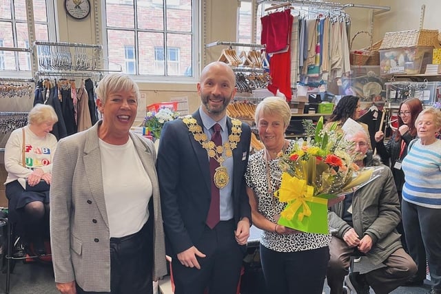The Mayor of Kirklees, Coun Cahal Burke, centre, was presented with a bouquet of players as the British Heart Foundation charity shop in Dewsbury town centre celebrated its 25th anniversary.