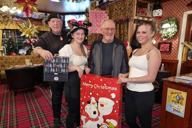 The Old Colonial, run by Tim Wood, far left, will be delivering Christmas hampers to veterans, including Glyn Parry, second right, in Mirfield. Also pictured are bar staff Abbie and Faye.