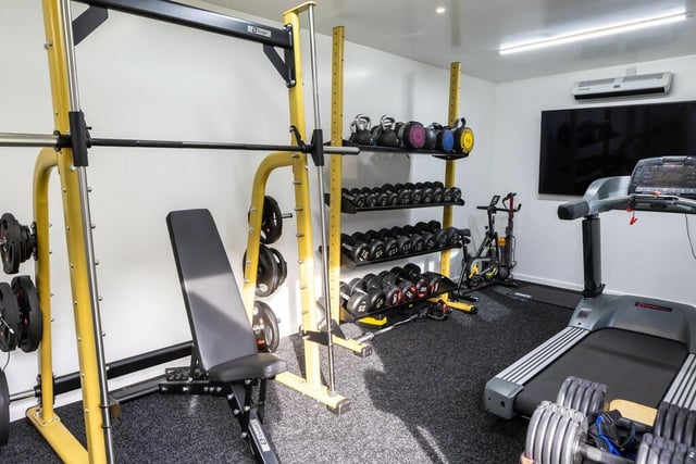 An external gym is fully kitted out with an additional storage area creating the option for an external workspace.