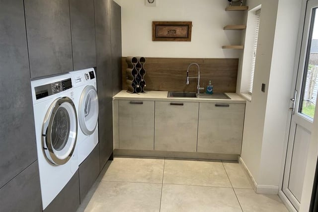 The utility room, which is set off the kitchen, comprises of storage cupboards, composite sink and drainer, plumbing for a washing machine and space for a dryer.