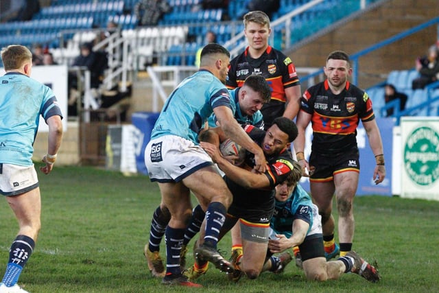 Three Rovers players tackle a Rams player.