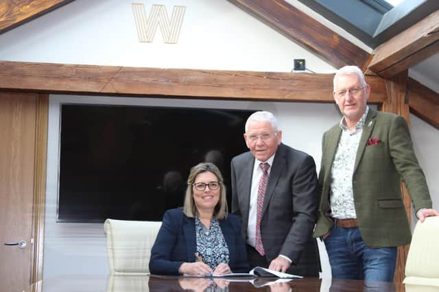 Joshua Adams Menswear, owned by Stephanie (left) and Ray Norris (right), is set to move to Market Street in January 2023 after the site was acquired by Willow Properties. Robert Williams of Willow Properties is seen here in the middle.