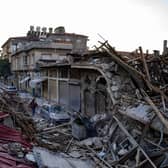 A man walks past the rubbles of destroyed building following two massive back-to-back earthquakes that affected both Turkey and Syria earlier in the week, in Antakiya, Hatay province, southern Turkey on February 10, 2023, with one million people estimated to be in urgent need of food. (Photo by Yasin AKGUL / AFP) (Photo by YASIN AKGUL/AFP via Getty Images)
