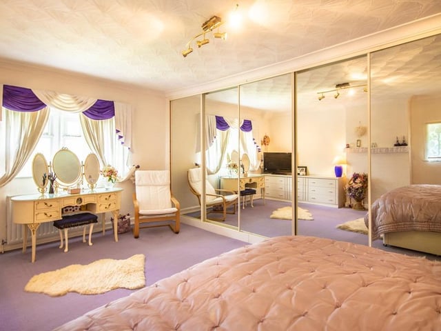 This stylish bedroom has mirrored wardrobes spanning one wall.