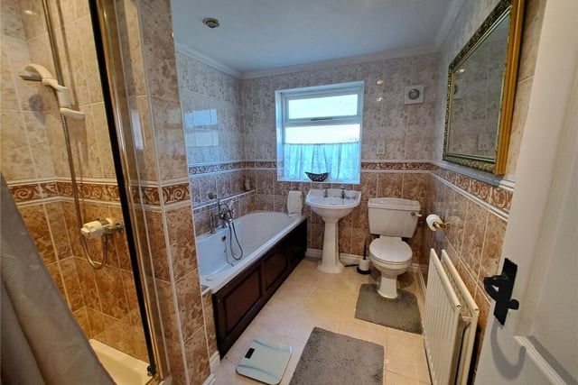 A stylish tiled bathroom with both bath and separate shower unit.