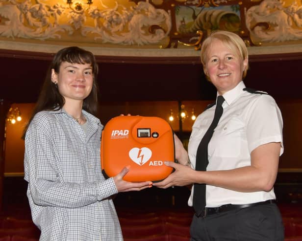 Assistant Chief Constable Catherine Hankinson of West Yorkshire Police presenting a new defibrillator to Izzy from Theatre Royal Wakefield.