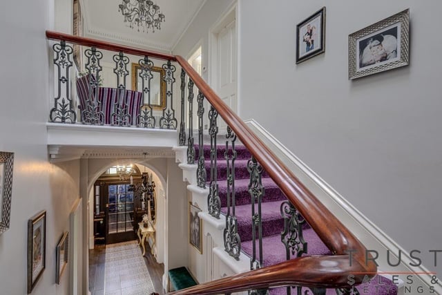 A majestic hallway and feature staircase leading to the upper level.