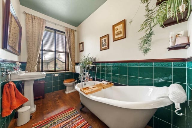 A part-tiled bathroom with free standing bath tub.
