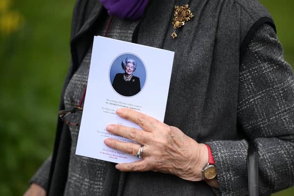 A mourner carries an order of service as they leave after attending the funeral of former Speaker of the House of Commons, Betty Boothroyd, at St George's Church in Thriplow, near Cambridge