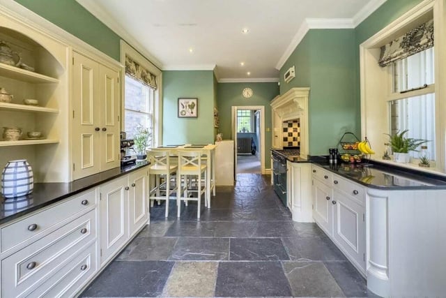 The stunning breakfast kitchen with granite worktops and a gas stove within an inglenook fireplace.