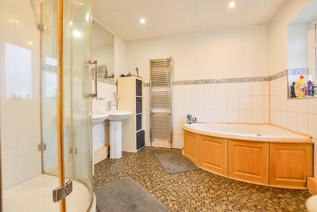This bathroom features a corner bath and a separate shower unit.