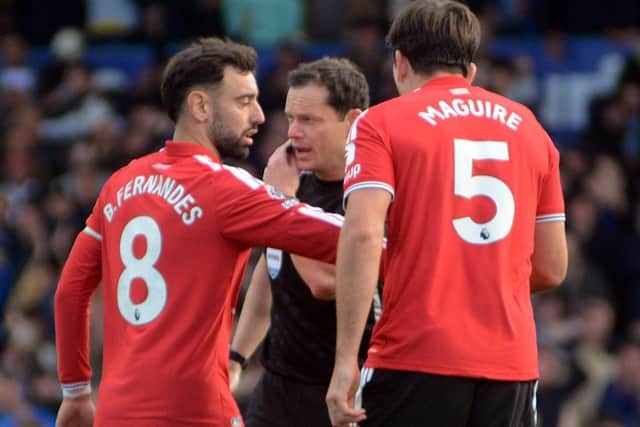 Manchester United players complain to referee Darren England.