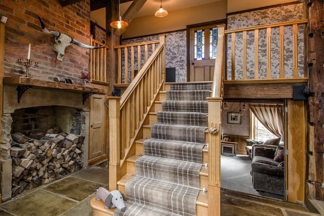 Staircase and landing with a large feature fireplace.