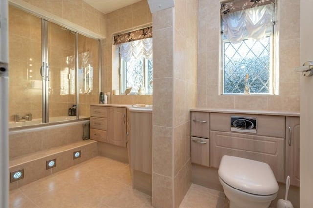 A stylish tiled bathroom includes plenty of storage.