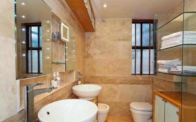 This shower room has his and hers wash basins, and vanit. unit storage.
