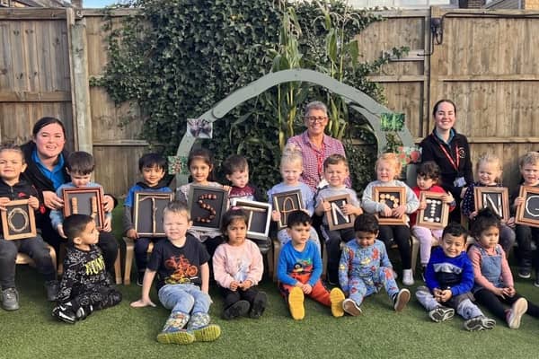 St John's Under 5's Pre-School's manager, Lorraine Pearson (middle, back), celebrates the settings' 'Outstanding' Ofsted grading with fellow staff members and children.
