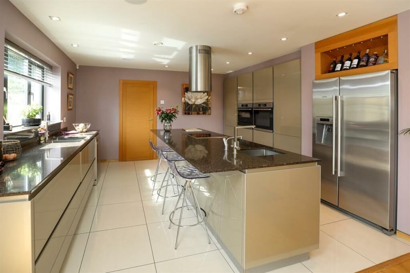 The immaculate kitchen has a large central island with breakfast bar.