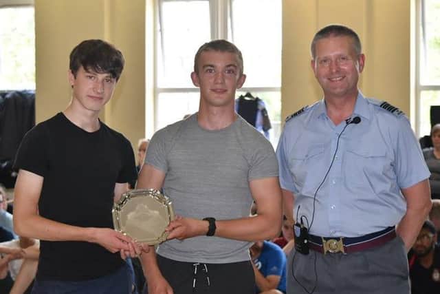 Wing Commander Brian Daniel presents the Young Adult First Aid trophy to Corporals Christian Bartey and Jonathan Barrett.