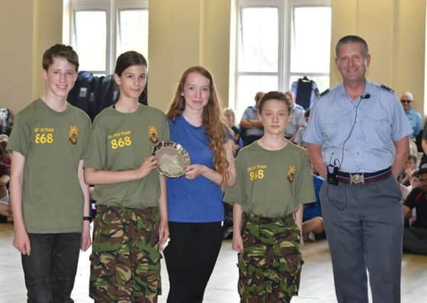 Wing Commander Brian Daniel presents the Youth First Aid trophy to cadets Daniel Bartey, Laila Robinson, Freya Pugh and Toby Mathews.
