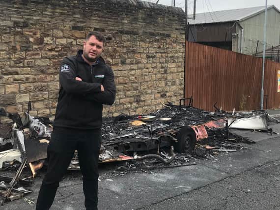 Jamie Skinner has asked for the remains of a burnt caravan to be moved from outside his business.