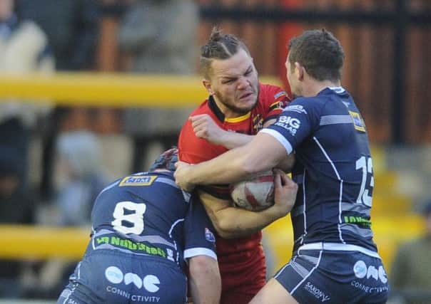 Dewsbury's Kyle Trout is tackled by Featherstone defenders Luke Cooper and James Lockwood. Picture Tony Johnson.