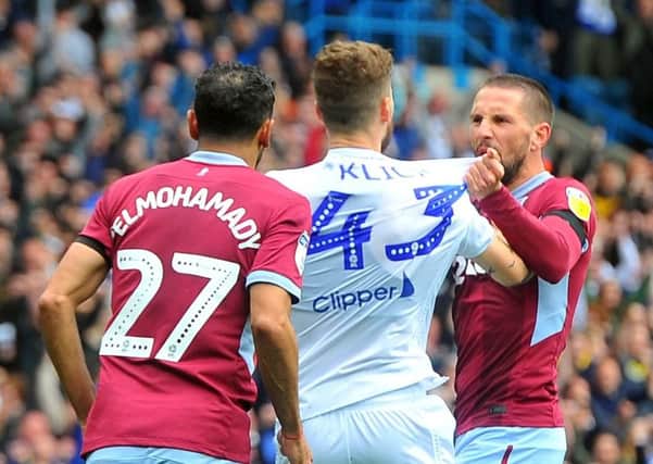 Aston Villa's Conor Hourihane angrily confronts Mateusz Klich after he played to the whistle to put Leeds United in front. Picture: Tony Johnson.