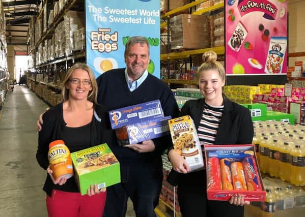 Andy Needham of Approved Food hands over donations to Lisa Bottomley and Ellena Roberts from the Town Foundation.