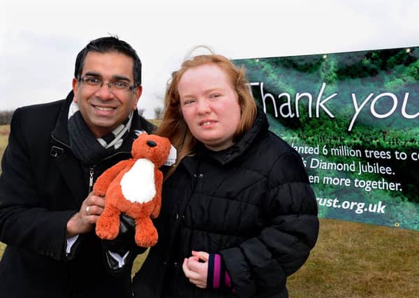 Kirklees Council leader Coun Mehboob Khan presenting Jessica Clark with a soft toy squirrel as a prize for choosing a name for the park's mascot.  (d606a315)