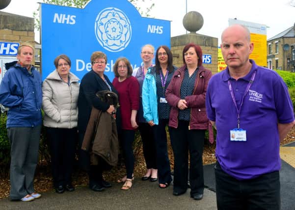 Union members endorsing a report which says a consultation into downgrading Dewsbury hospital is 'phony'. Dave Byrom and other members in front of the sign. (D546D321)