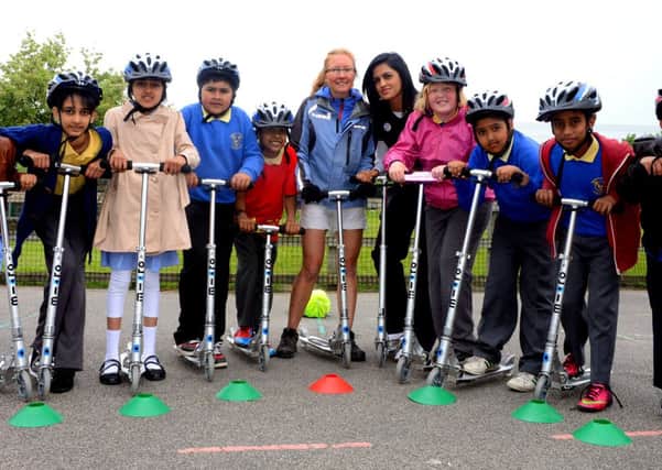 WHEELY GOOD FUN: Pupils practice their scooter skills with Sulstrans' Carly Webster and Haseeba Shaikh of Kirklees Council. (d623a324)