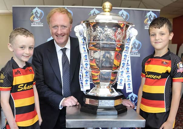 Simon Reevell the Dewsbury MP shows young players Theo Robinson 7 (left) and Amir Sghaier 7 from Shaw Cross Sharks the Rugby League World Cup, the Cup was also taken to Dewsbury Moor Rugby Club.