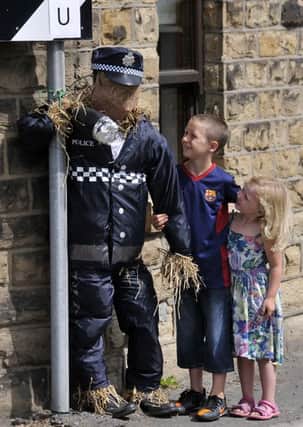 Ross McDermott 7 and his sister Lois 4 meet up with a 'policeman' in Church Lane at Hartshead Village Scarecrow Festival.