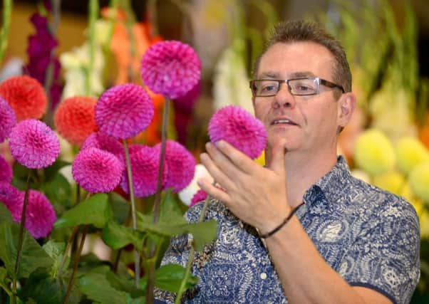 IN BLOOM Alan Wilkinson admires entries in the flower classes. (D551N335)