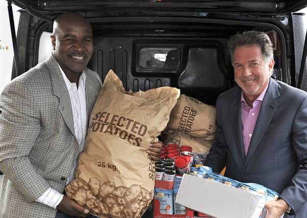 Champion boxer Evander Holyfield visited Shaw Cross Community Church to meet One Community trustee Chris Battye to see what he can do to lend his support to its work in Kirklees,he brought with him a van load of food stock accompanied by (right) Yank Barry, Chairman and Co-founder of Global Village Champions Foundation.