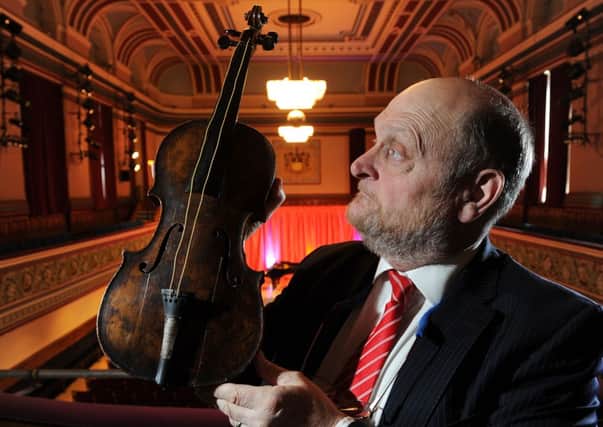 HOLY GRAIL Auctioneer Alan Aldridge presents Wallace Hartley's violin at Dewsbury Town Hall.