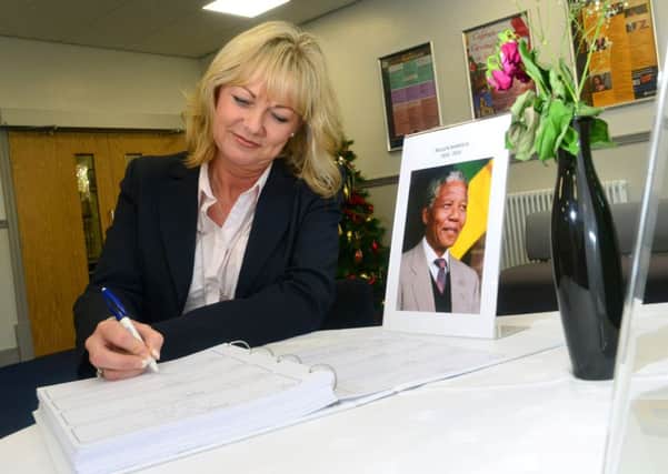 Cathryn Riley signs the book of condolence to Nelson Mandela. (D559D350)