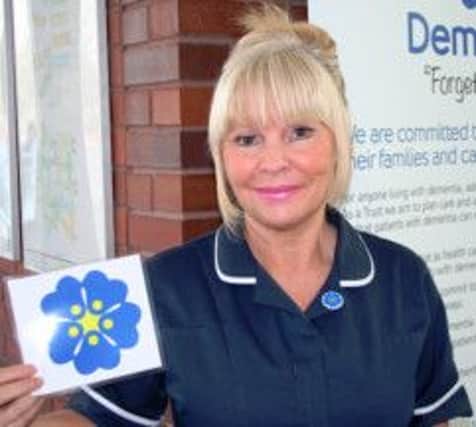 OUR COMMITMENT Mid Yorkshire senior Sister Anita Ruckledge with the forget-me-not flower symbol linked to its dementia campaign.
