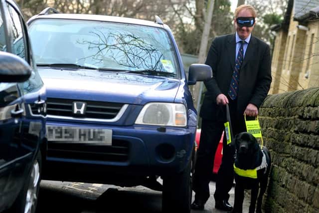 Simon Reevell MP was blindfolded and lead by a guide dog to raise awareness about guide dog issues. (D553C402)