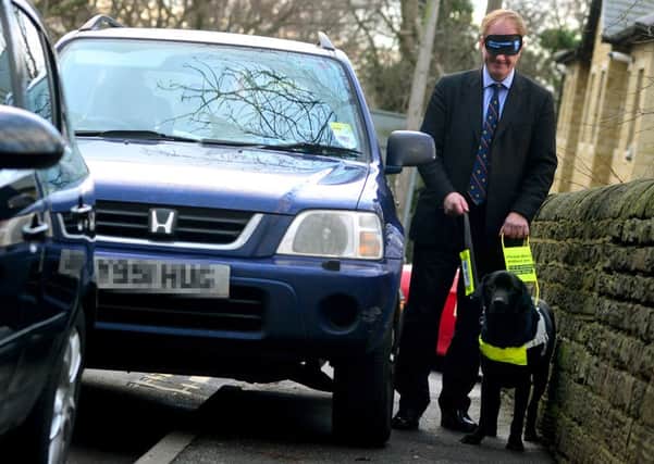 Simon Reevell MP was blindfolded and lead by a guide dog to raise awareness about guide dog issues. (D553C402)
