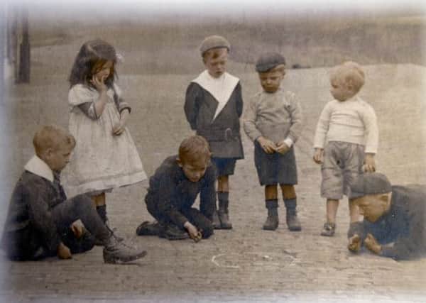 SUMMER DAYS This picture, taken 1917, shows children playing marbles in Ward Street, Crackenedge, Dewsbury. Sadly, the little boy standing with the white collar, Alec Crossland, died only a few months later. The names of the other children are not known. The picture was kindly loaned by Alecs sister, Joyce.