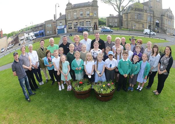 GROWING SUCCESS Pupils from Whitechapel, Howard Park and Heaton Avenue schools help to plant flowers at the Savoy site for the Cleckheaton in Bloom competition. (d312a420)
